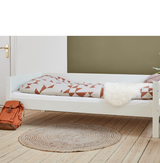 Huxie hvid halvhøj seng med dyne, rygsæk, og tæppe på trægulv