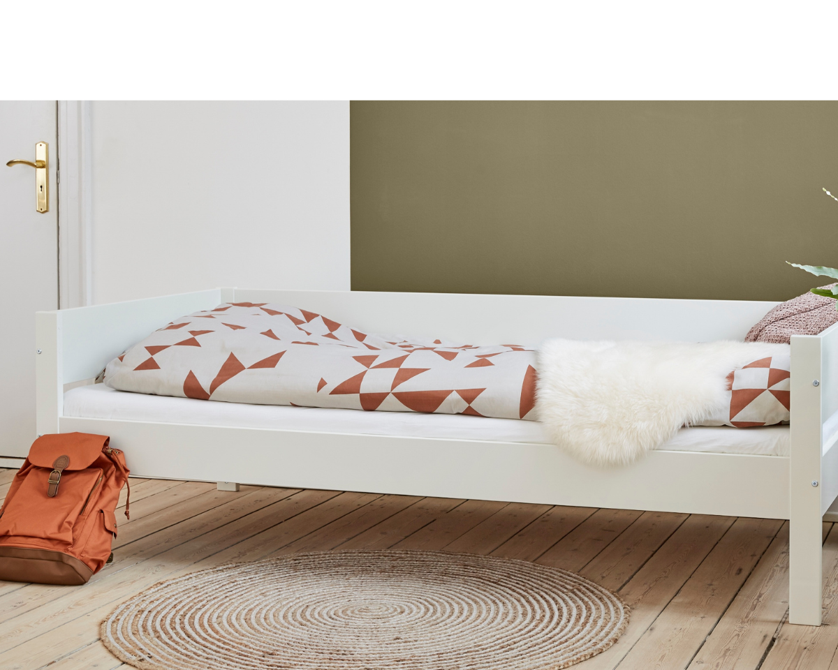 Huxie hvid halvhøj seng med dyne, rygsæk, og tæppe på trægulv